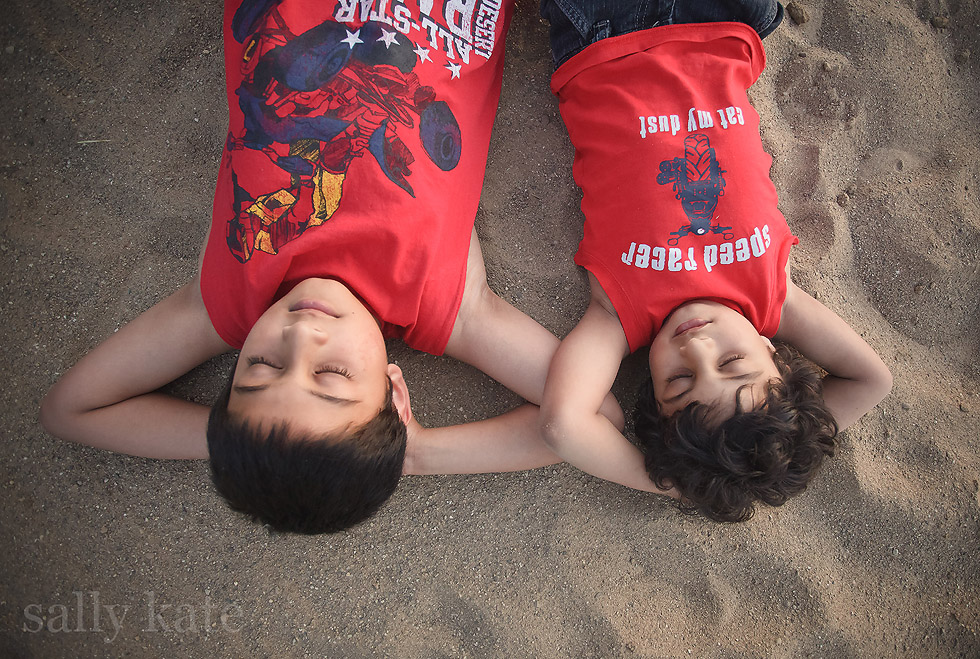 novi michigan two brothers lying in sand eyes closed