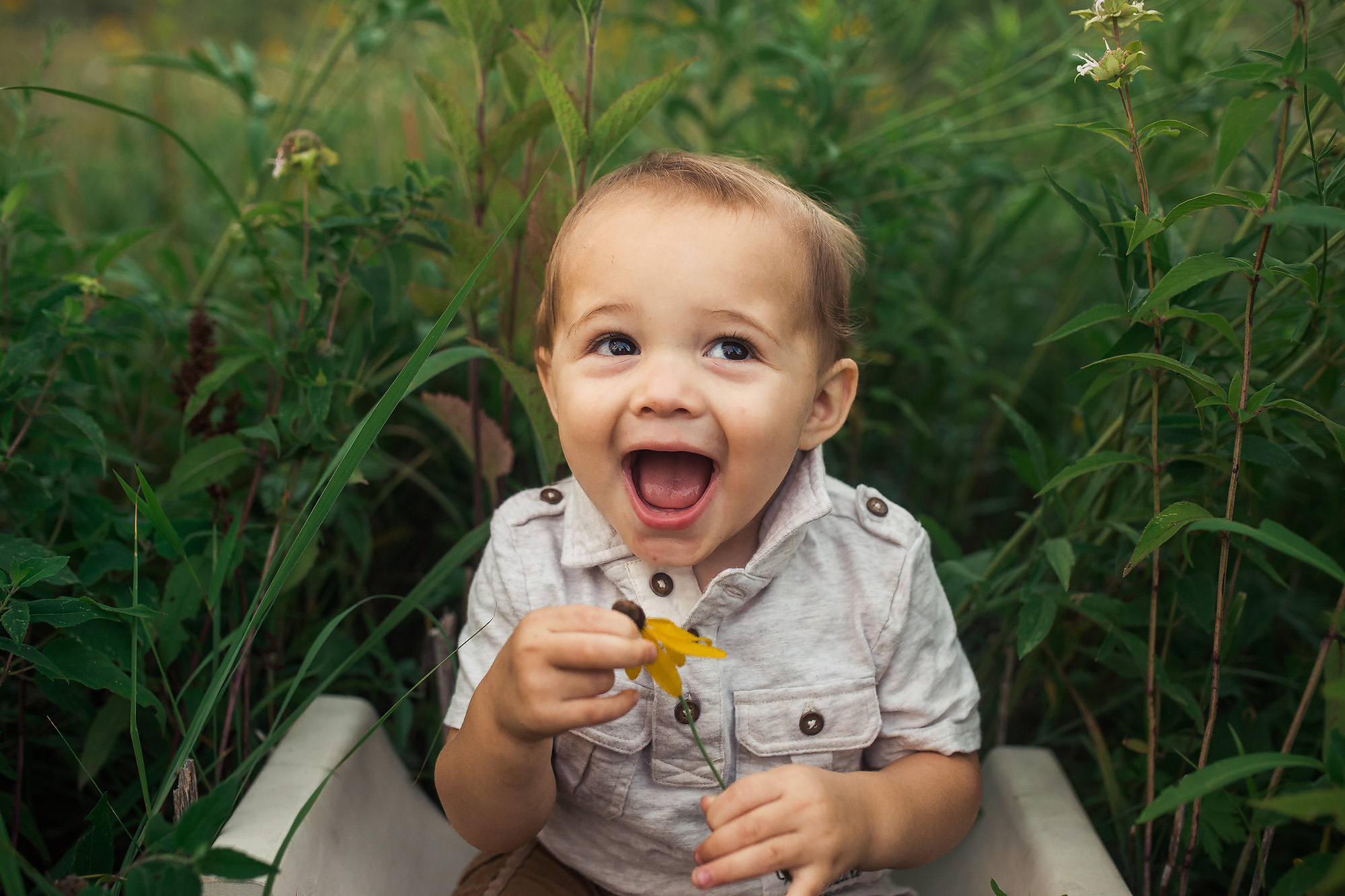 toddler boy big smile with flower