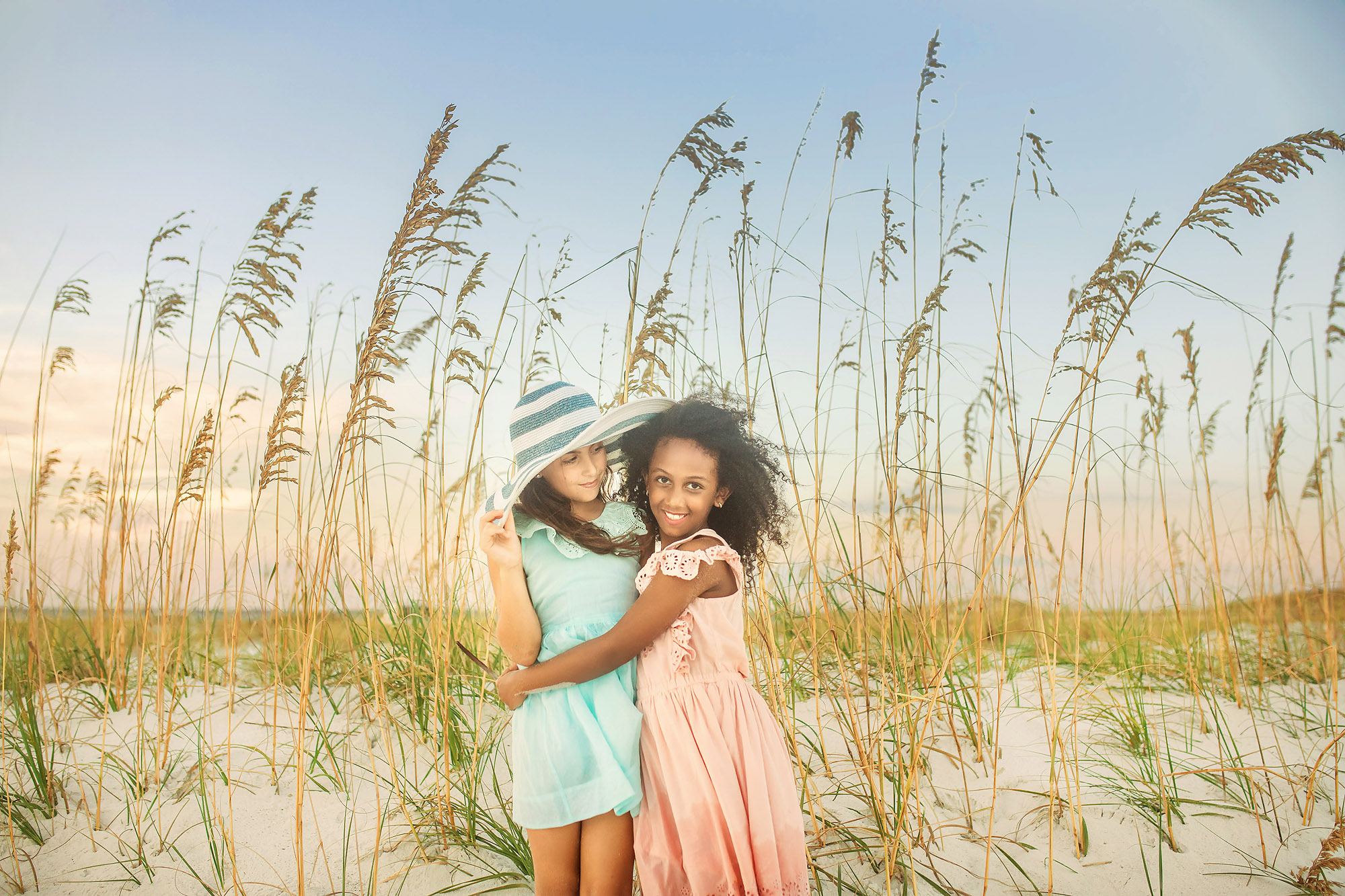 girls hugging tall grass beach