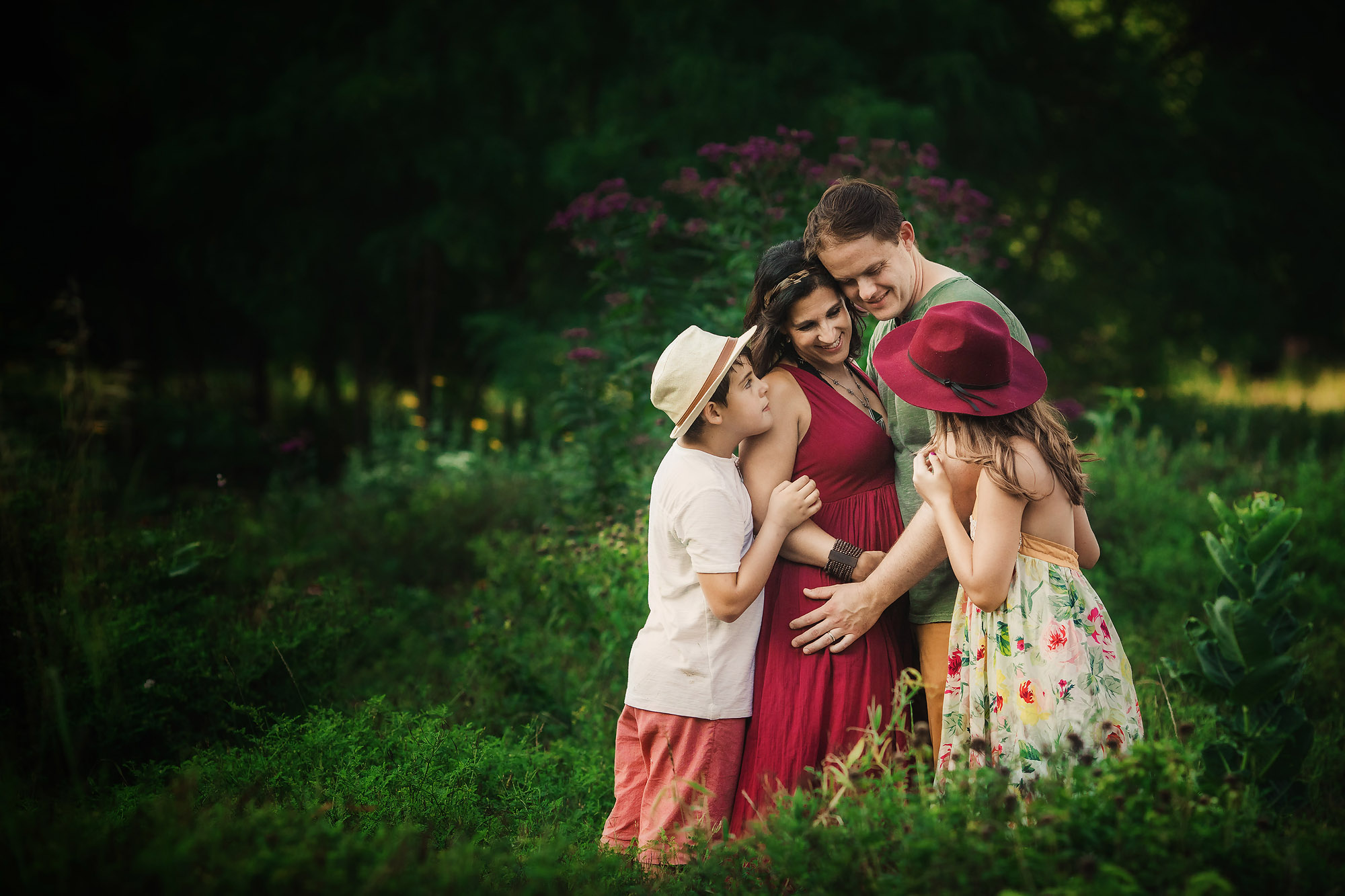 family cuddles in flower field