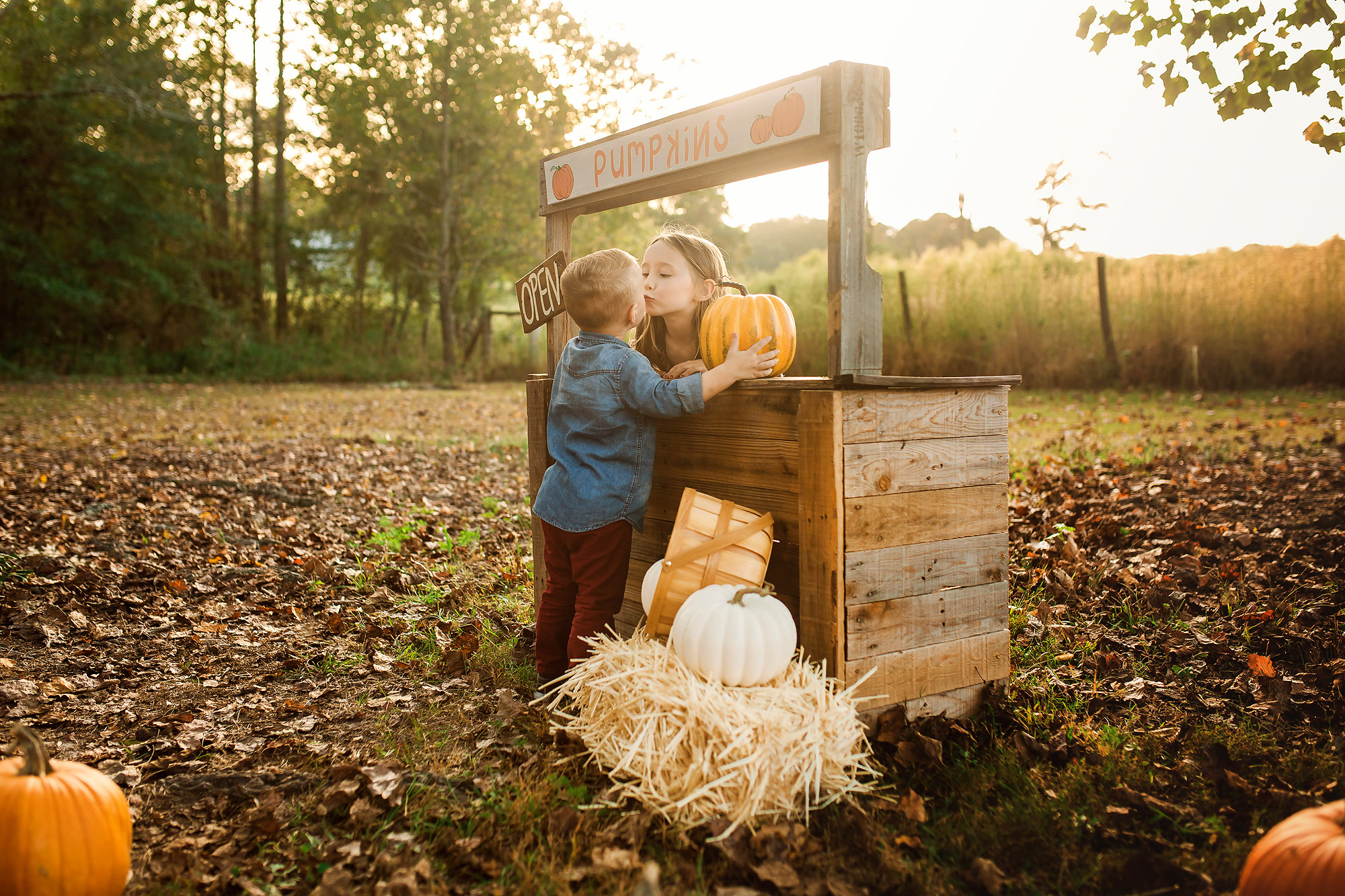 brother sister kissing pumpkin stand