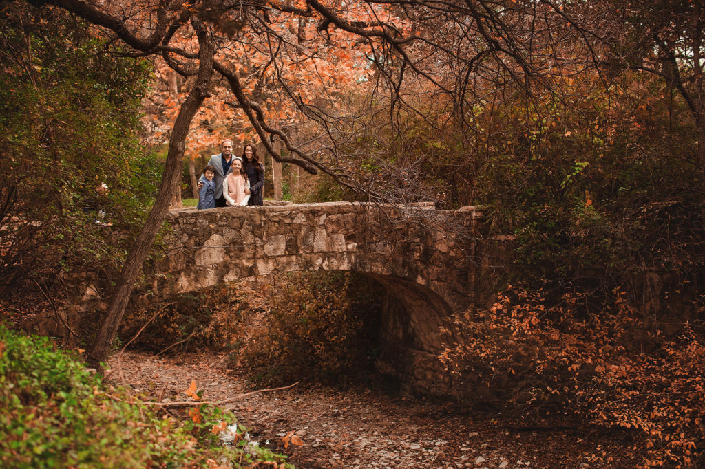 family on bridge under fall leaves