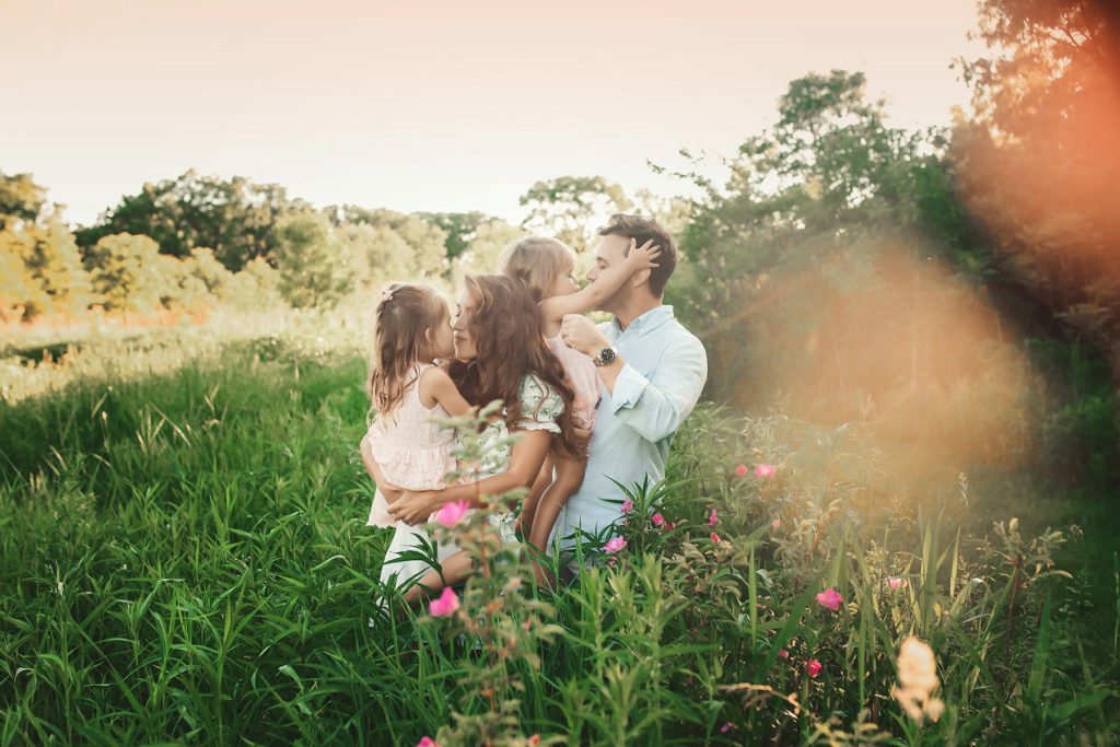 family in flower field cuddling
