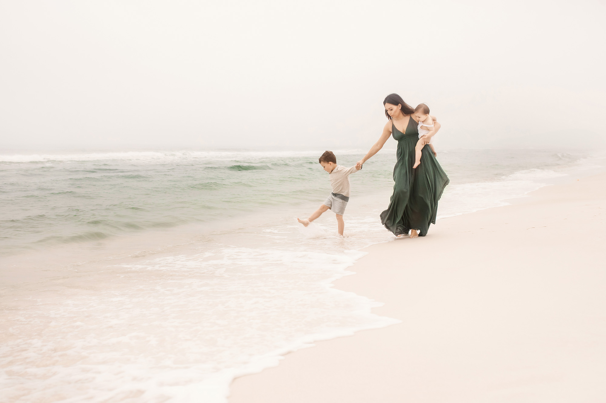 mother with children walking foggy beach