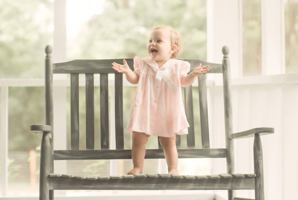baby girl clapping on bench back porch