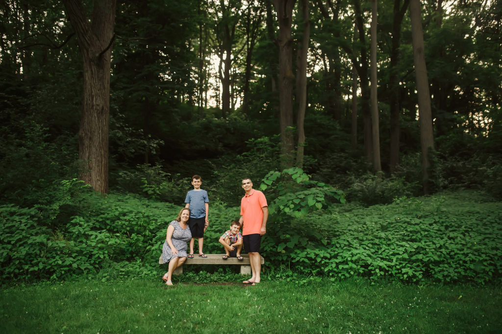 michigan family of four on bench tall trees
