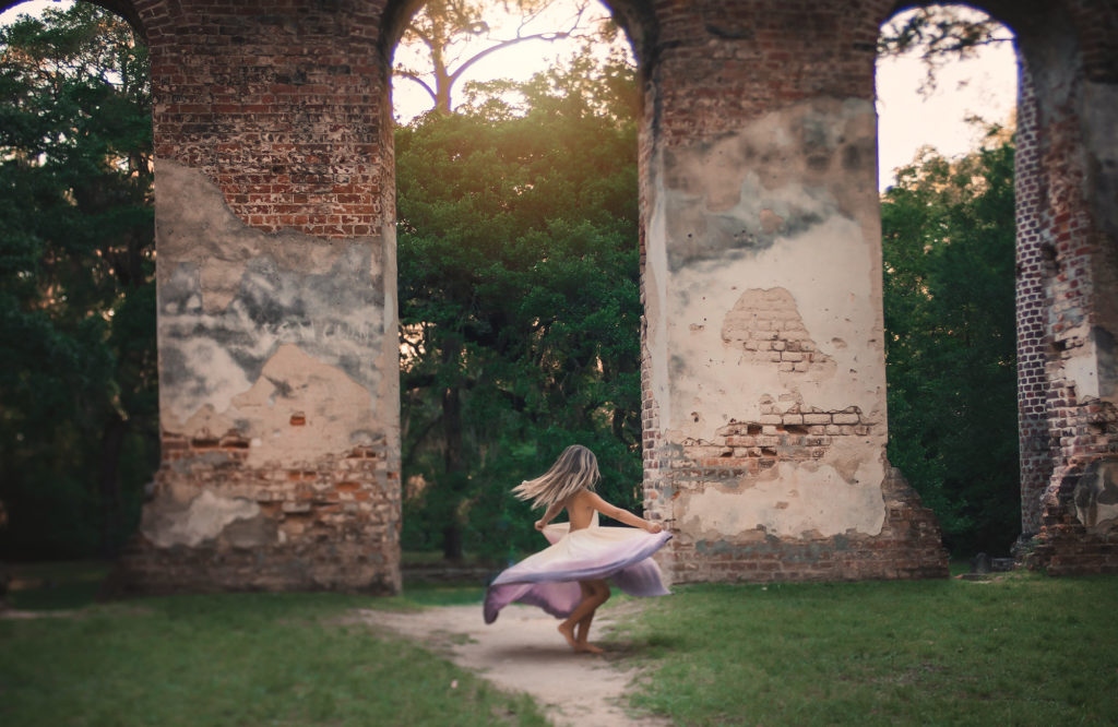 girl dancing by old church walls spinning