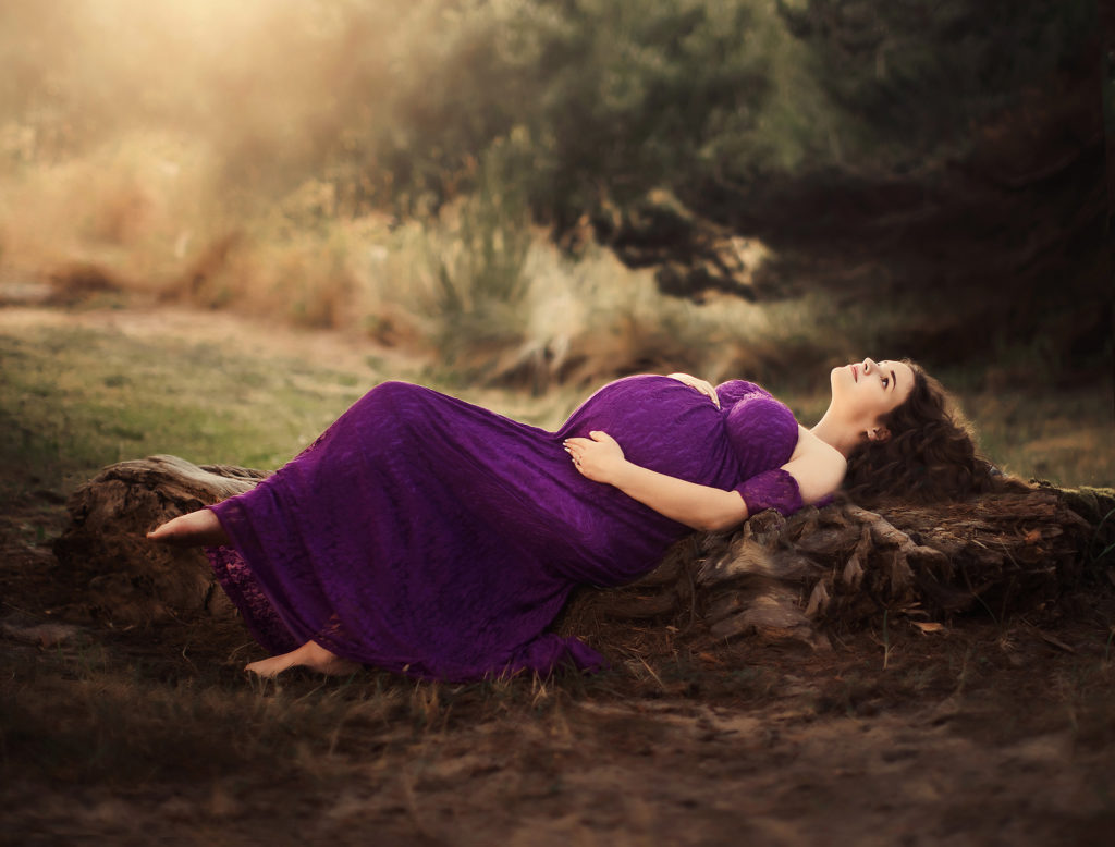 maternity woman purple dress on log
