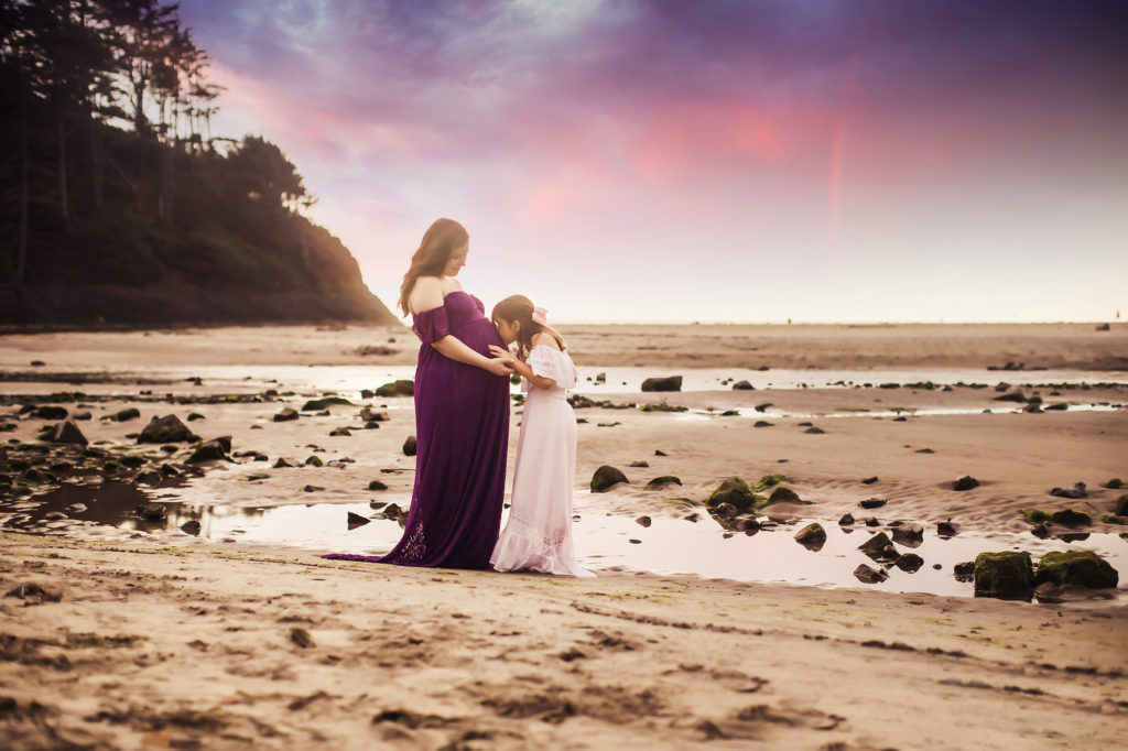 pregnant mother and daughter beach sunset