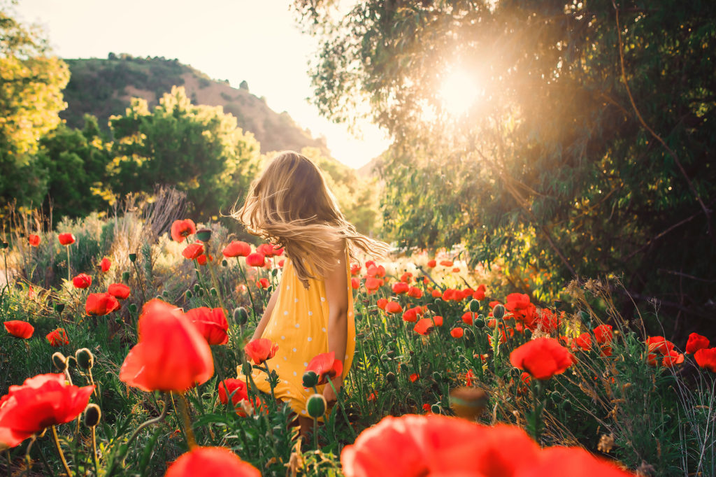 girl spinning in yellow dress poppies