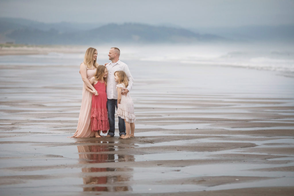 family on foggy beach in sand
