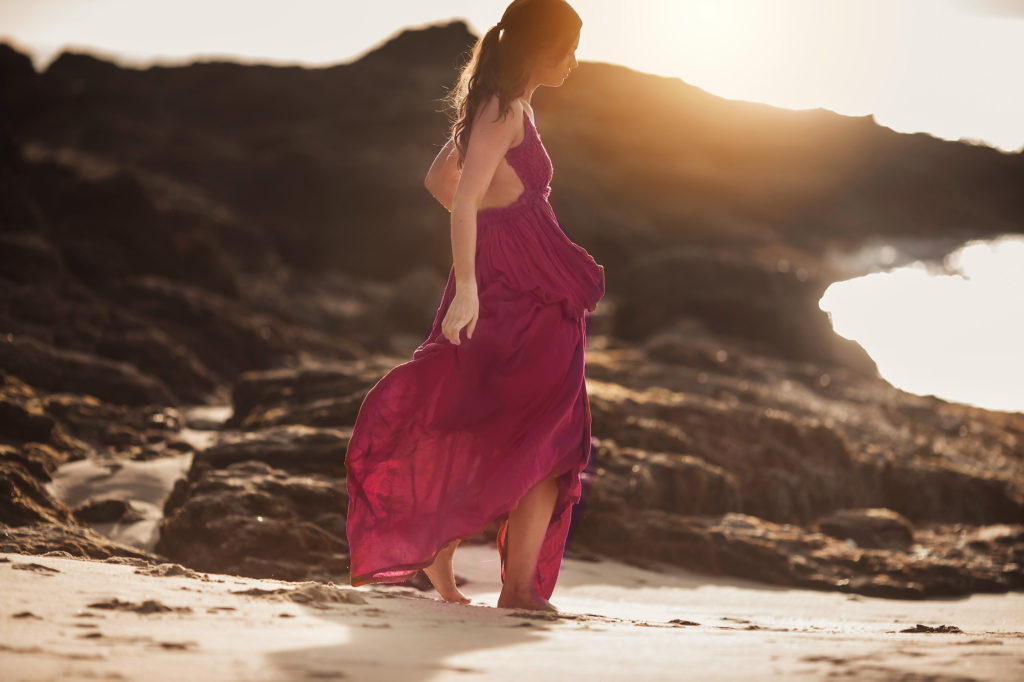 girl walking by ocean sunset purple dress