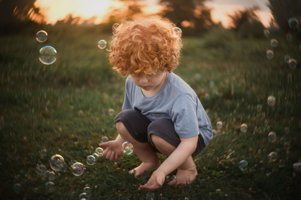 boy with curly red hair sunset bubbles