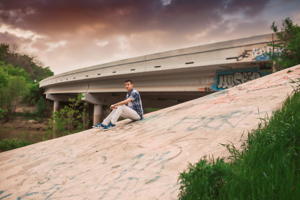 boy on pavement with graffiti senior pictures