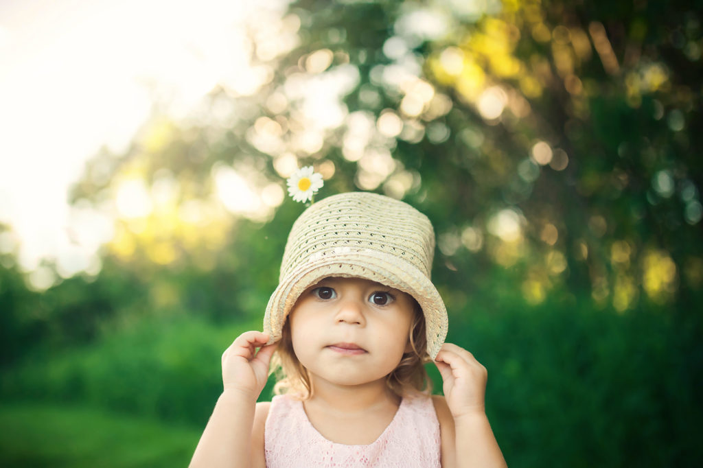 girl holding hat with daisy outdoor